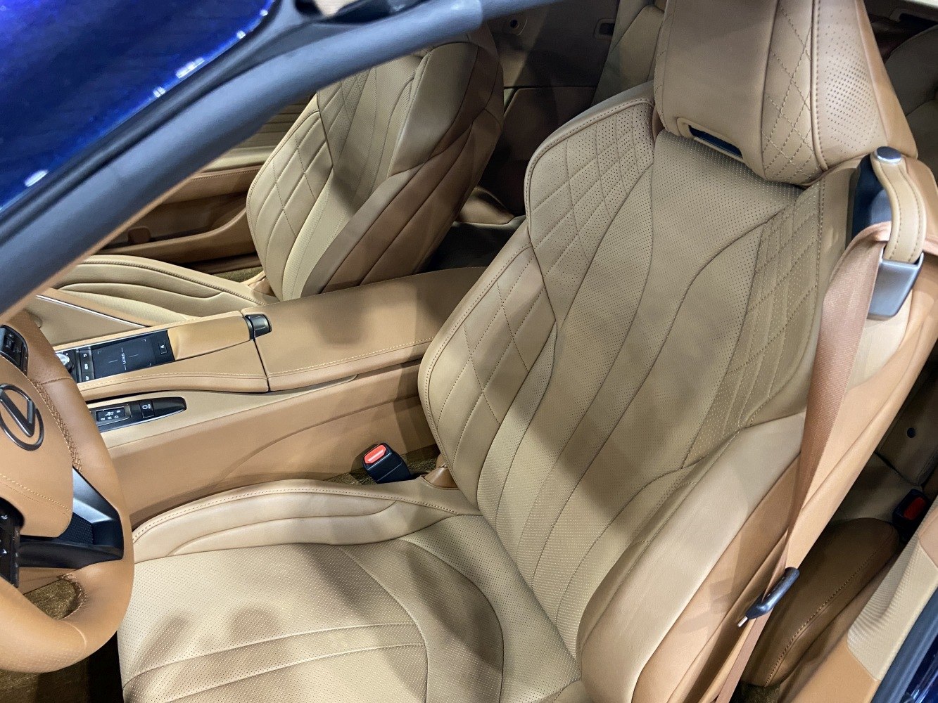 Beige leather seats with detailed stitching and center console controls