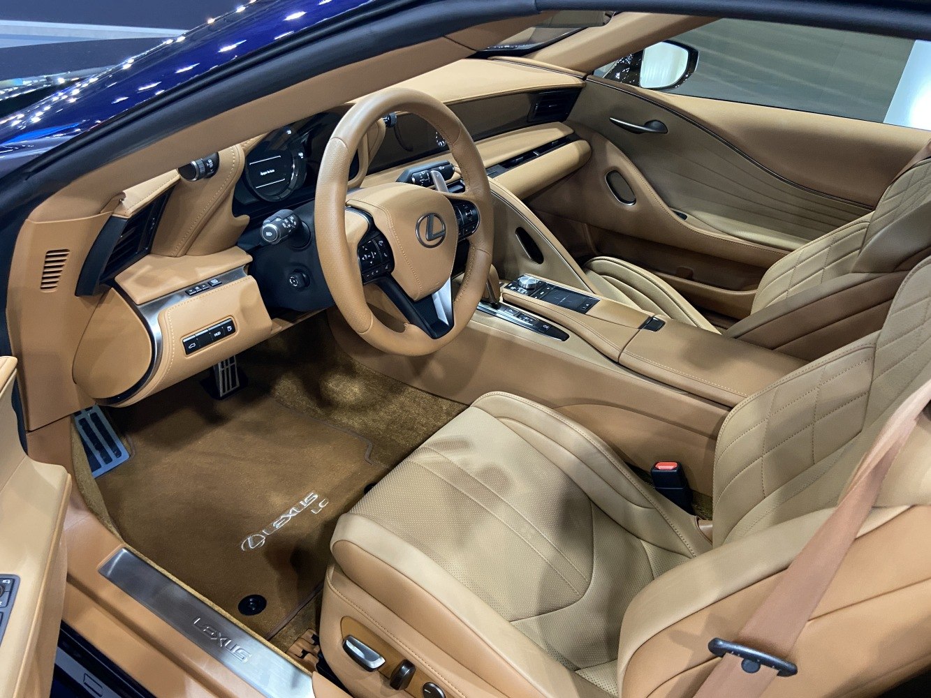 Tan leather seats and advanced dashboard inside a luxury convertible
