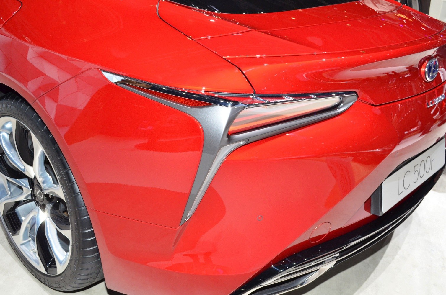 Rear sleek tail light and alloy wheel design on red sports coupe