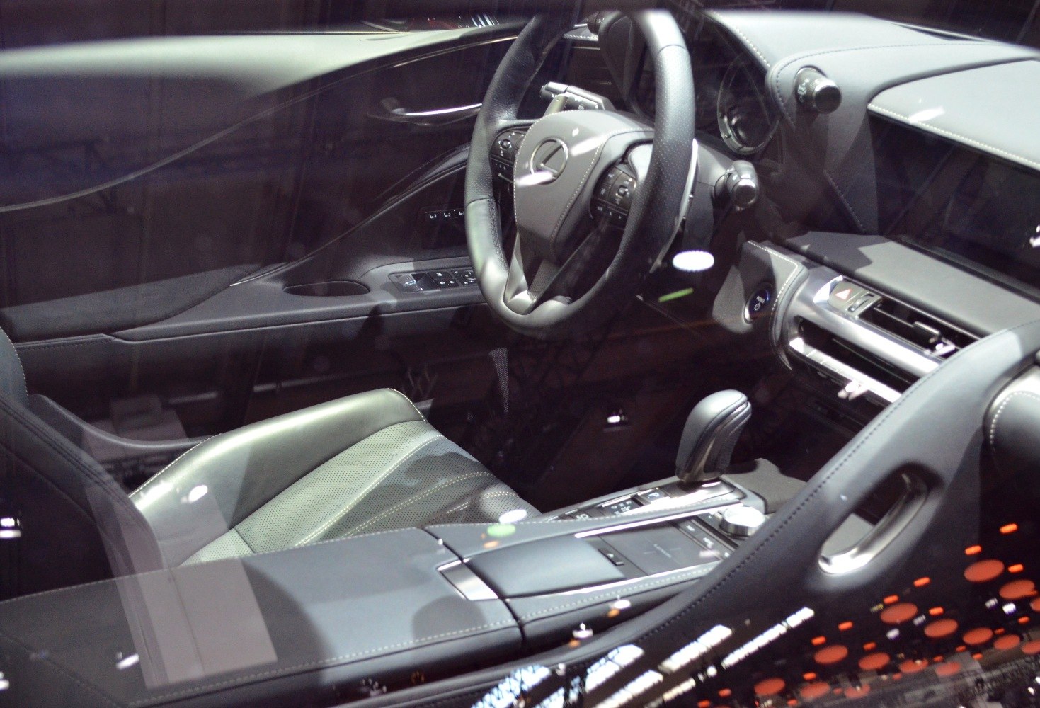 Luxury car interior with detailed steering wheel and dashboard.