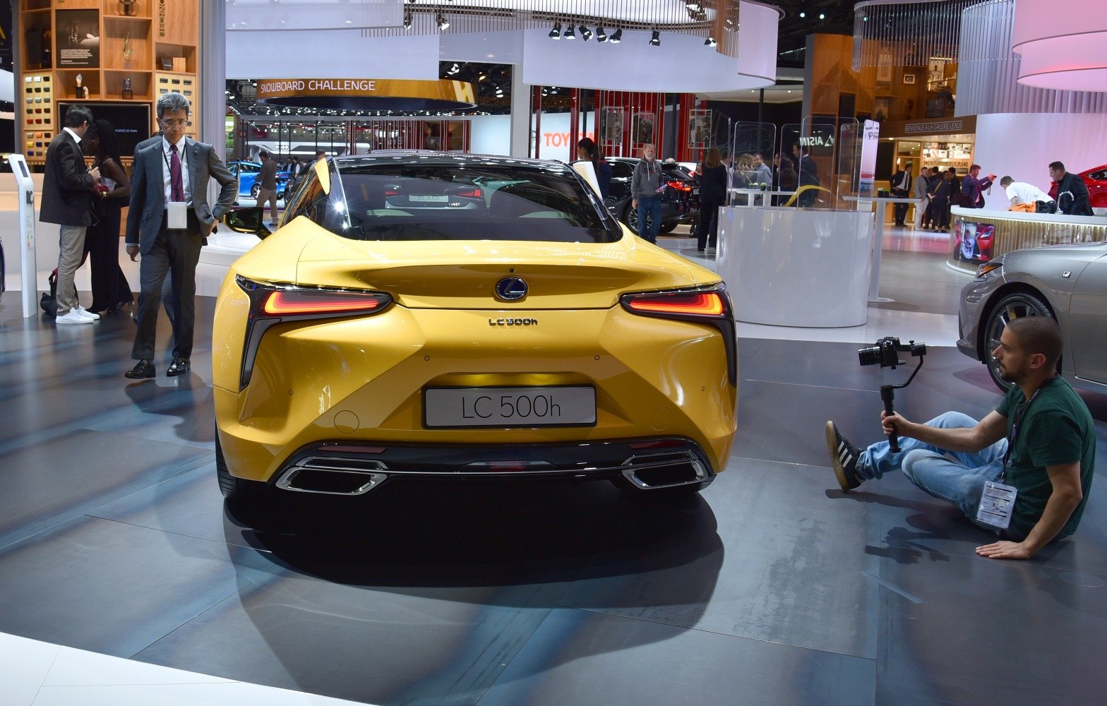 Futuristic LED tail lights and sporty dual exhaust of a yellow luxury coupe