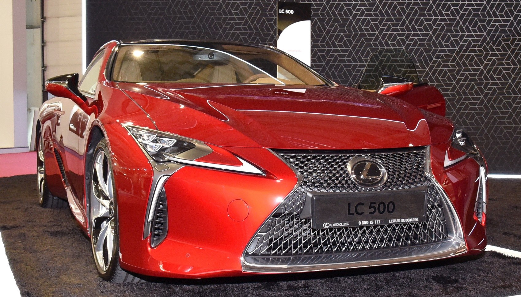 Red luxury coupe front with spindle grille and LED headlights