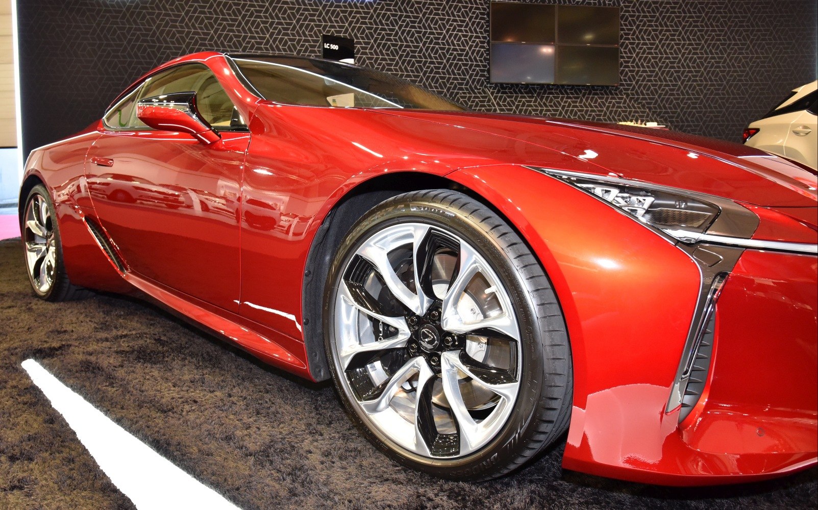 Red coupe with distinctive alloy wheels and sleek headlights