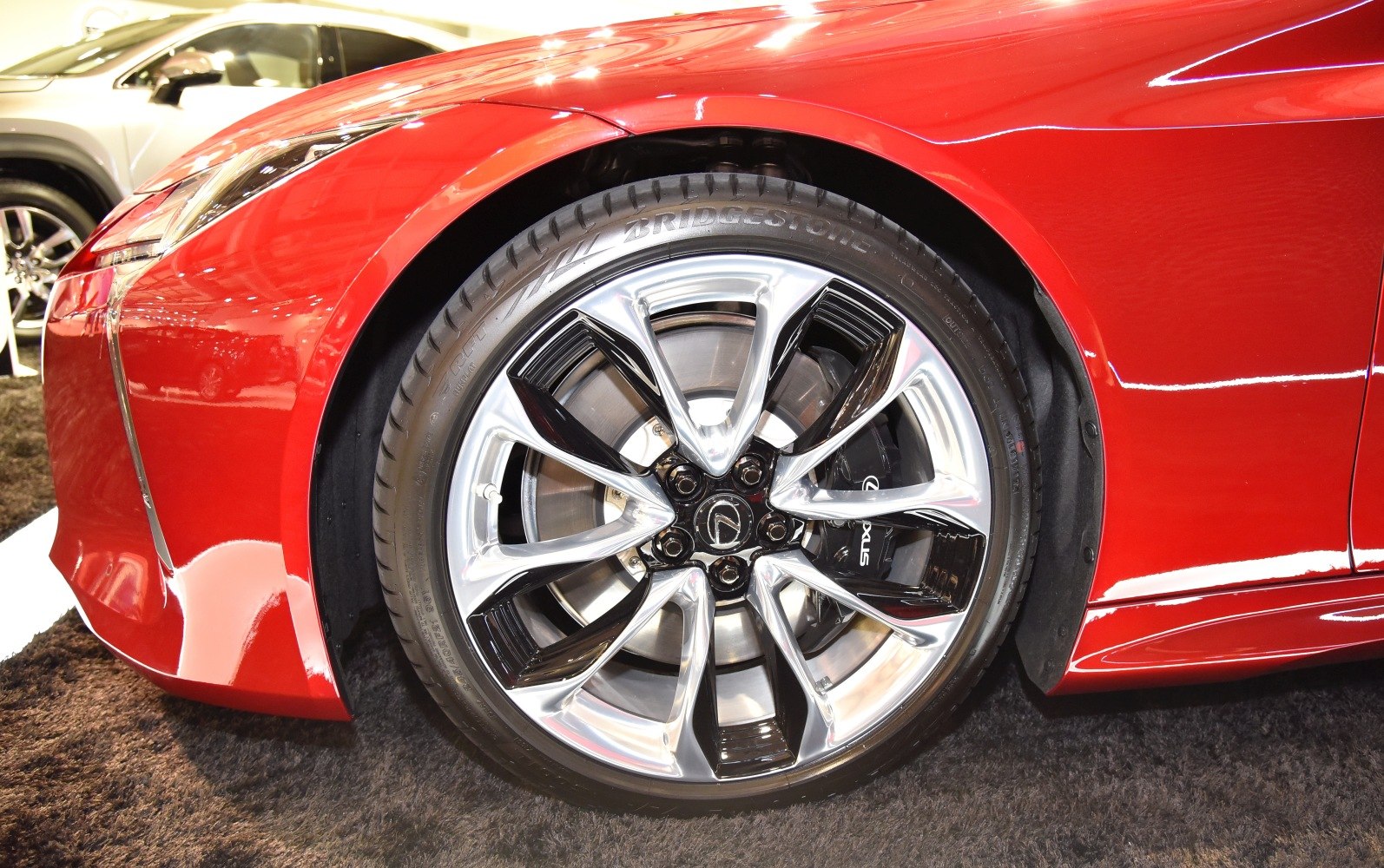 Close-up of alloy wheel and tire on red sports car fender