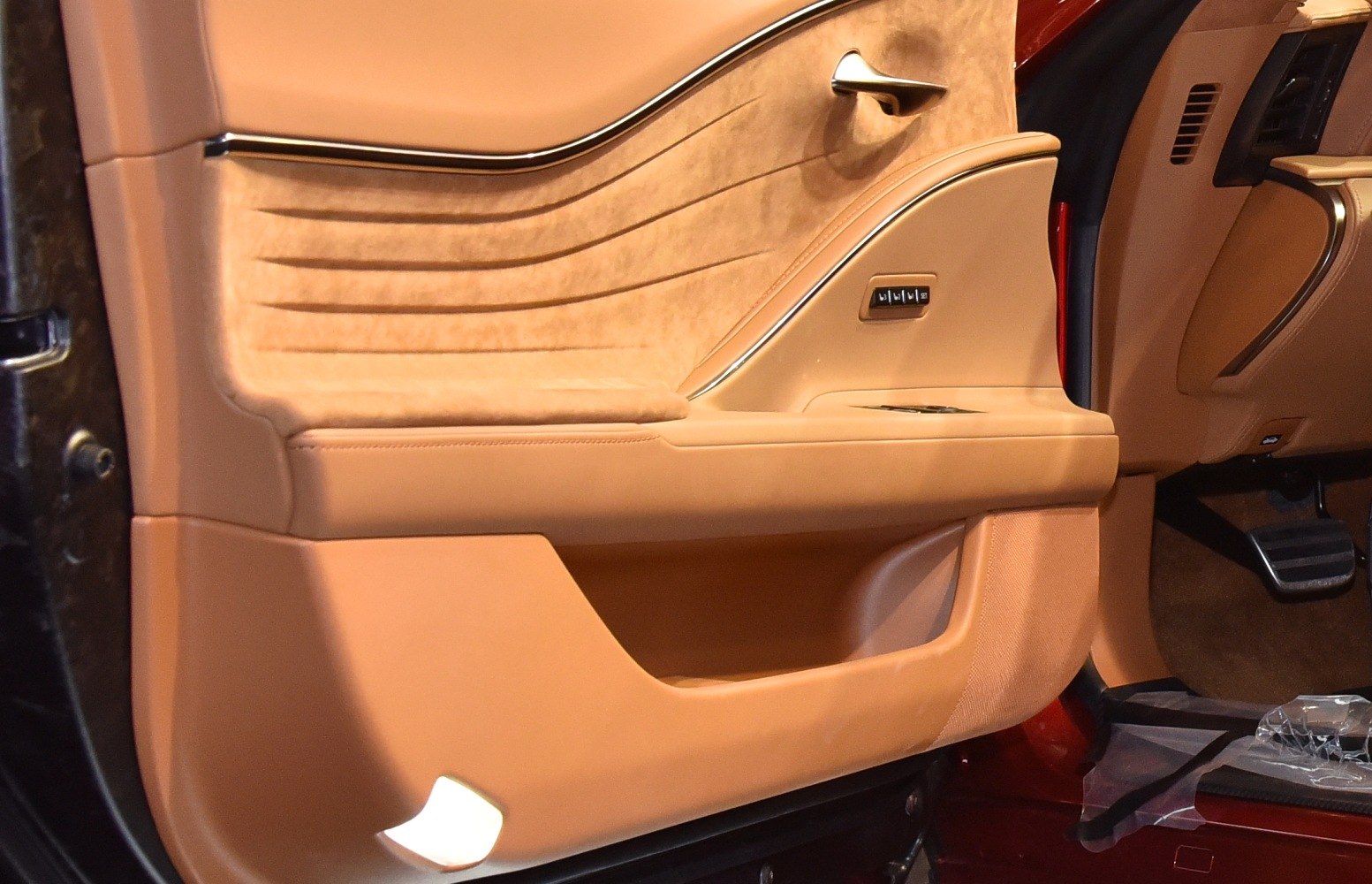 Luxury leather and suede car door panel with detailed stitching and controls