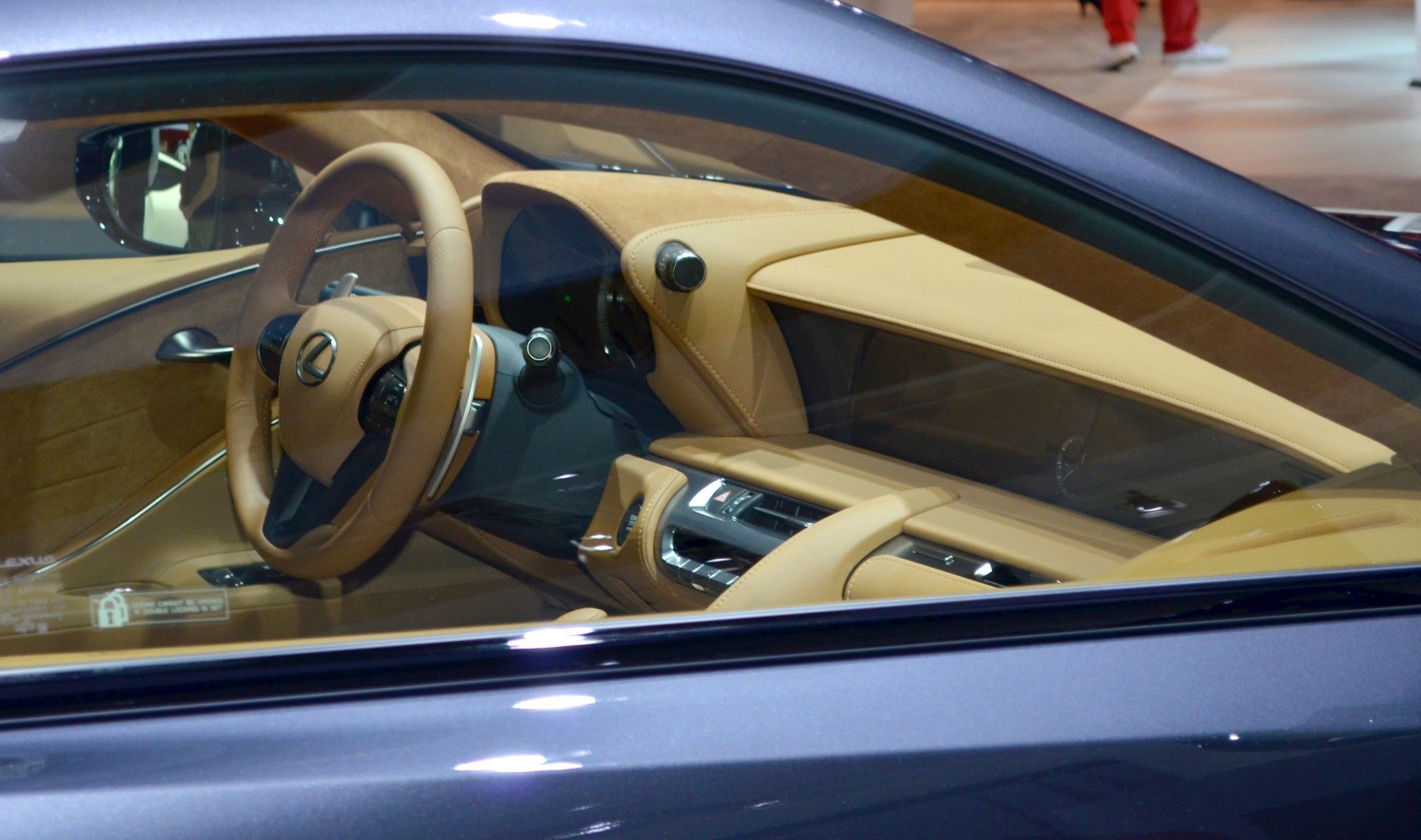 Luxury car interior with tan leather dashboard and steering wheel.