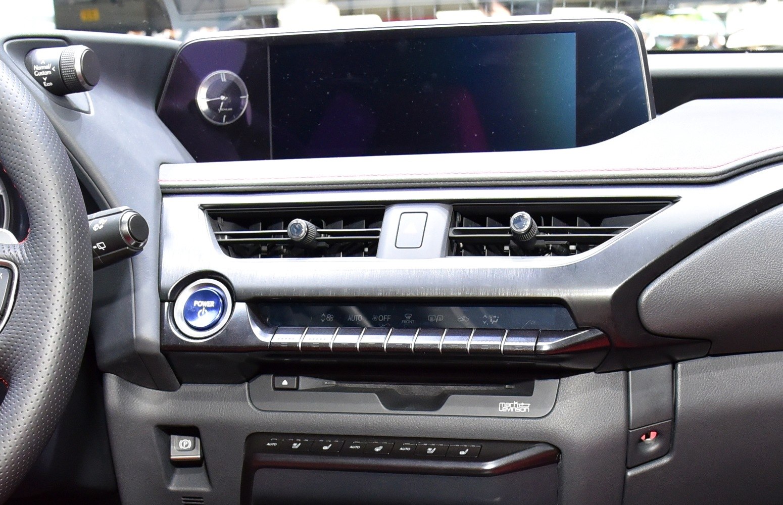 Dashboard controls and infotainment display with digital clock and push start button