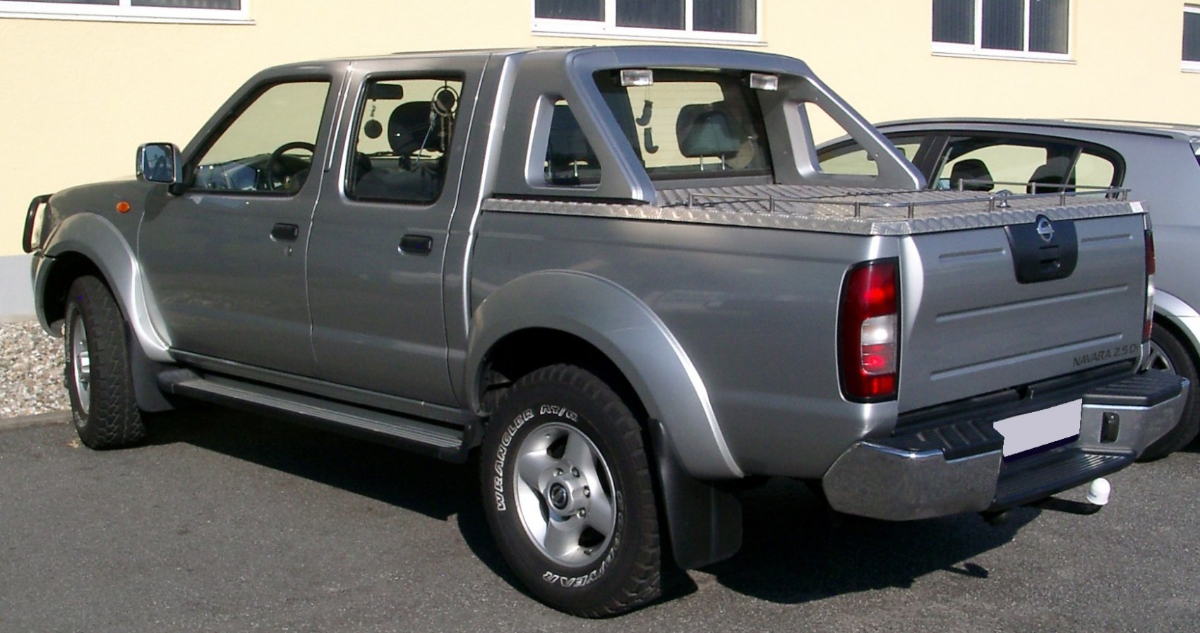 Side and rear view of double cab pickup with distinct wheel arches and open bed