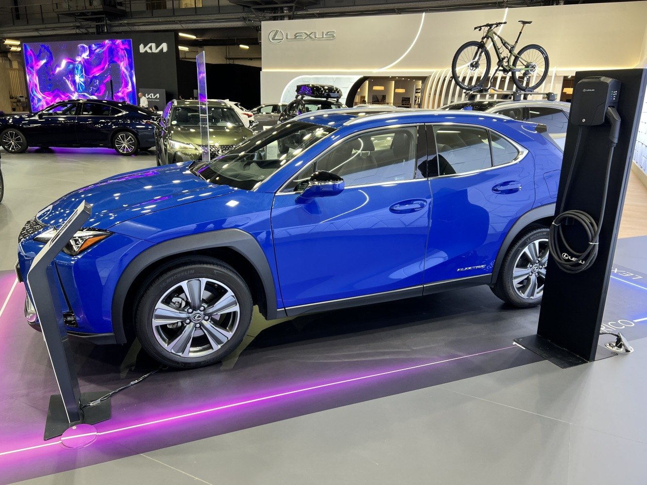 Blue electric SUV with roof bike rack and charging station