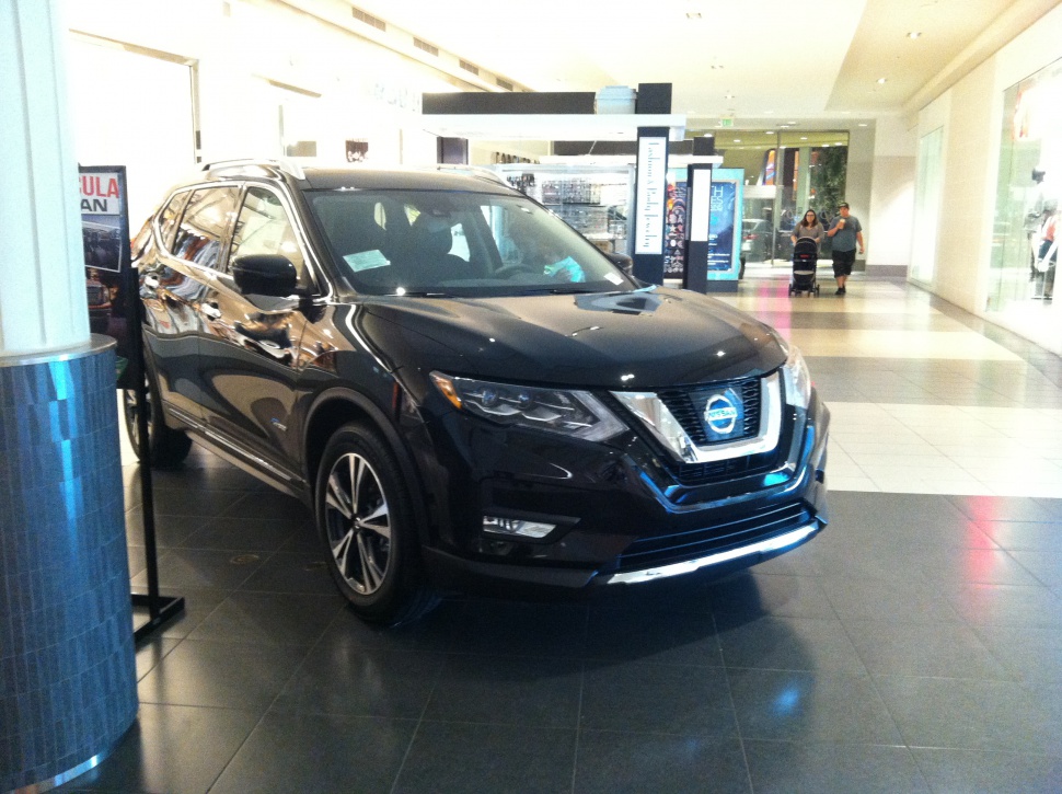 Front grille and side profile of black SUV in indoor setting