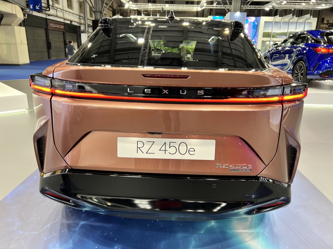 Rear view with continuous signature LED taillight and Lexus badge.