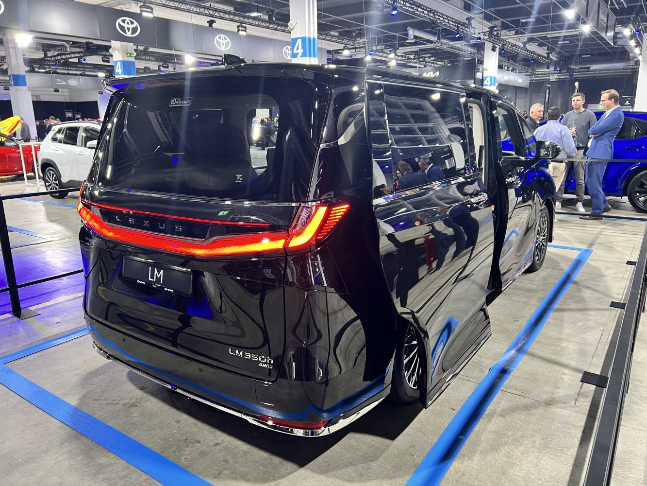 Rear view with illuminated LED tail lights and an open sliding door.