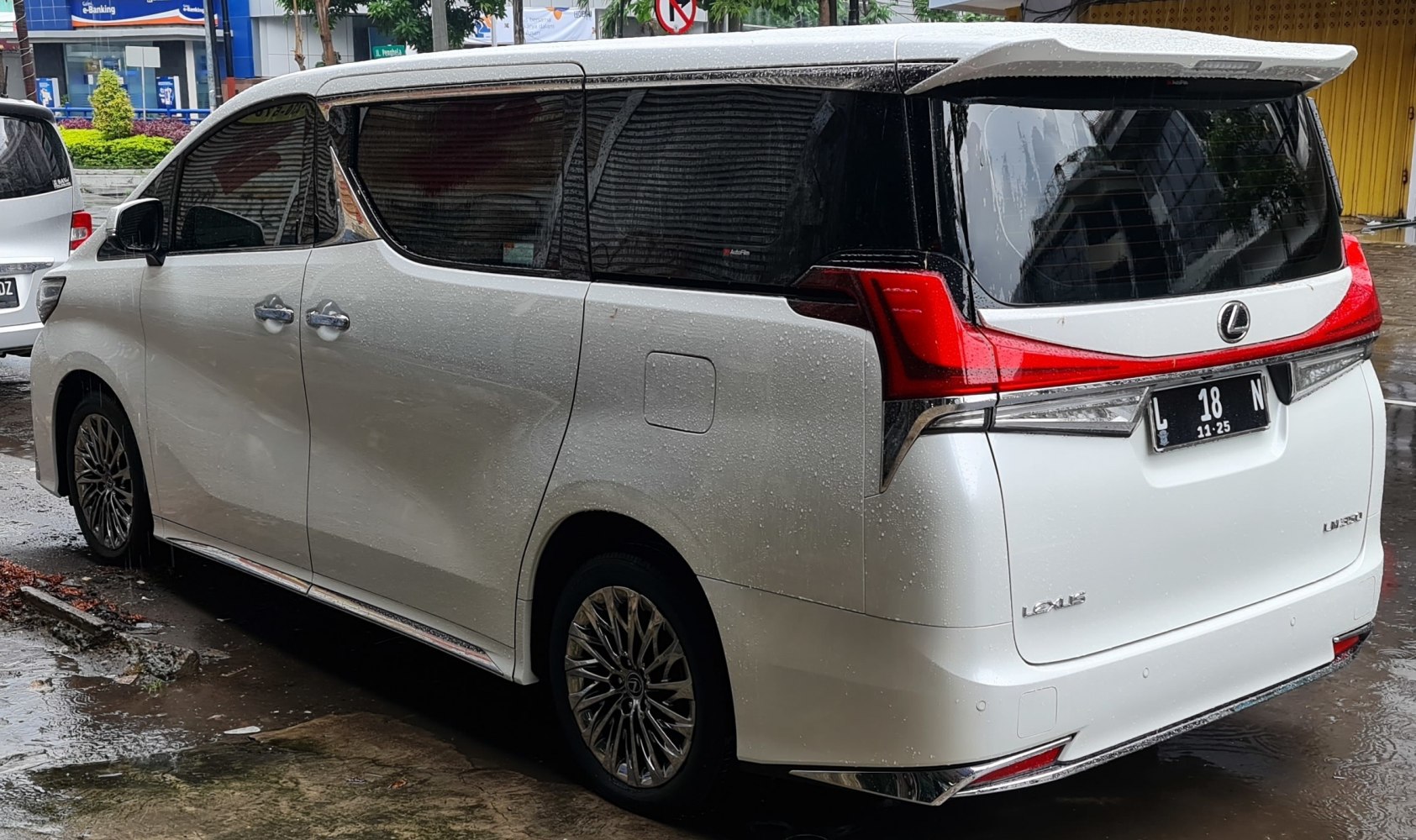 Rear and side view of luxury minivan with unique taillights and tinted windows.