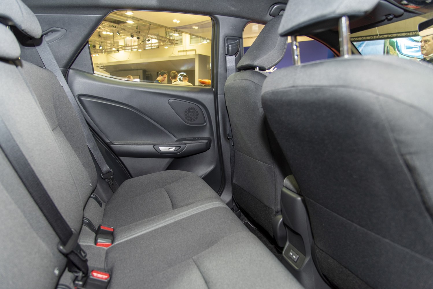 Rear seat and door panel with fabric upholstery and speaker grille