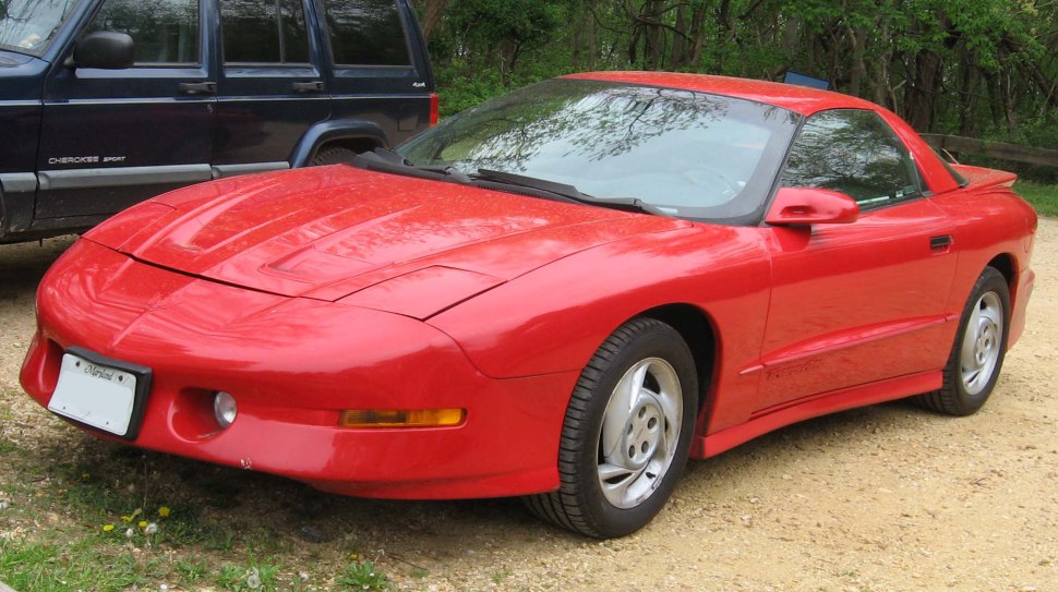 Red coupe with aerodynamic front and side design, integrated headlights.