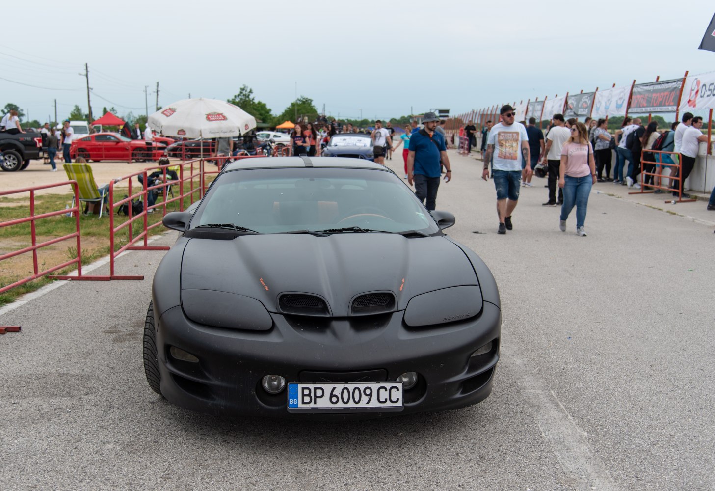 Front view of matte black sports car with hood scoops and aggressive styling