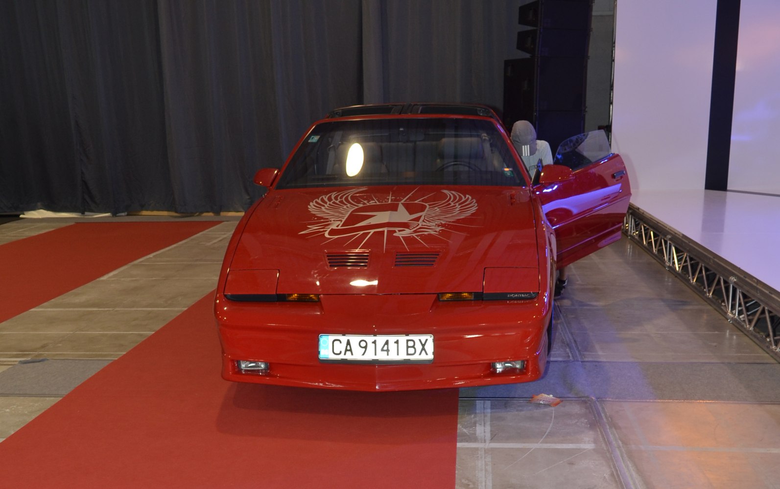 Red sports car front with winged hood decal and pop-up headlights