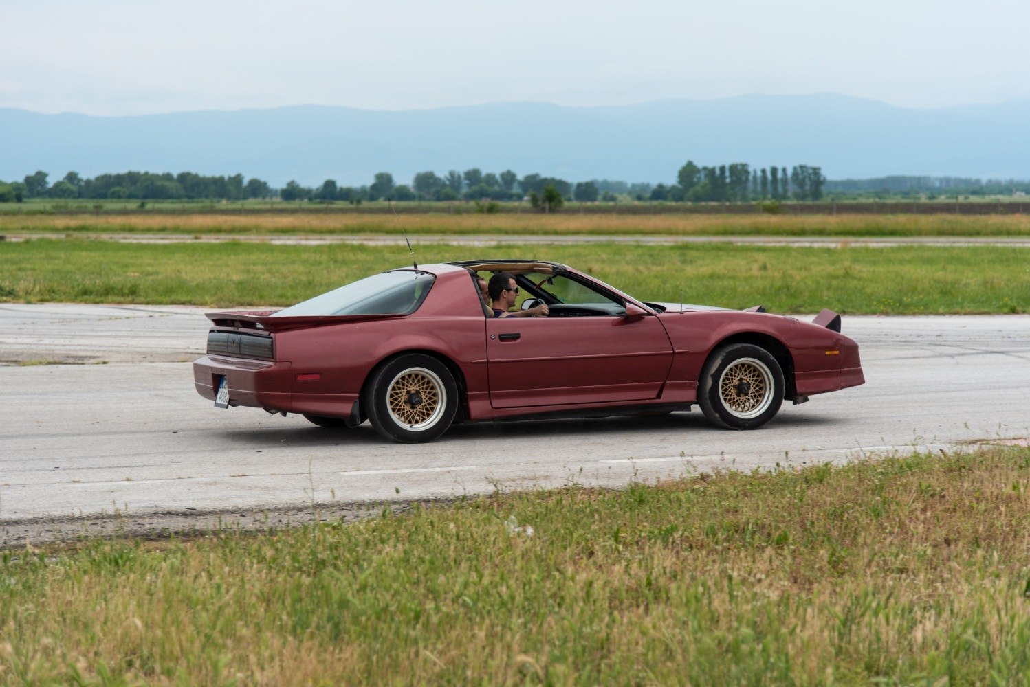 Red sports coupe with gold mesh wheels and pop-up headlights