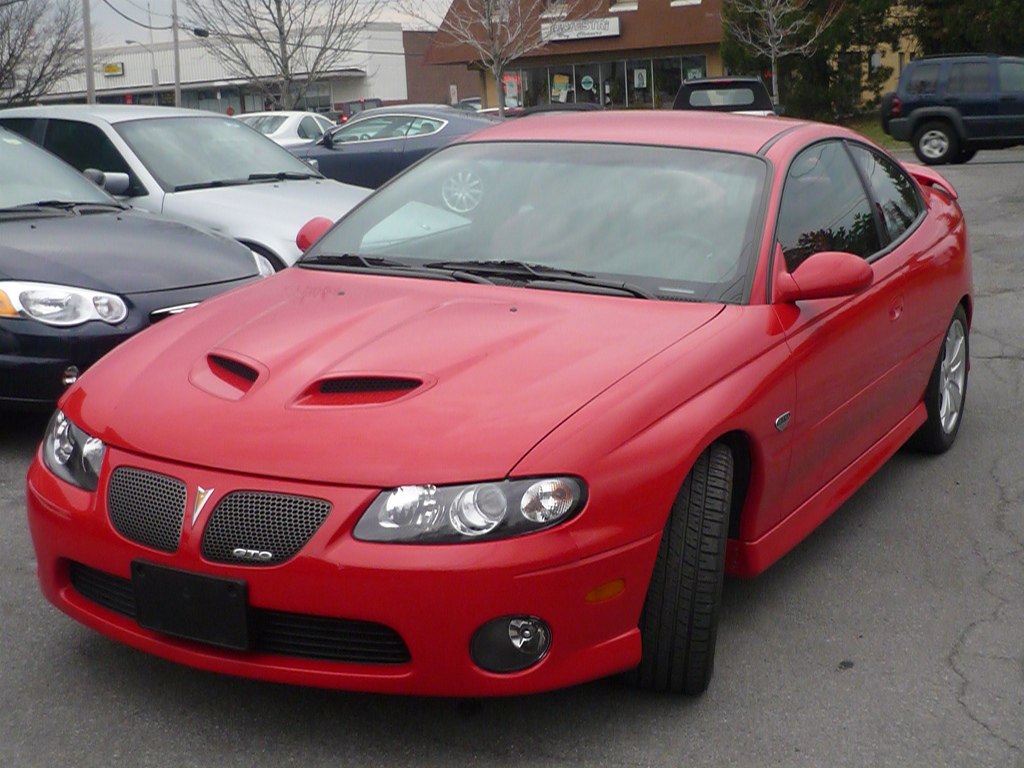 Red coupe with dual hood scoops and mesh grille front