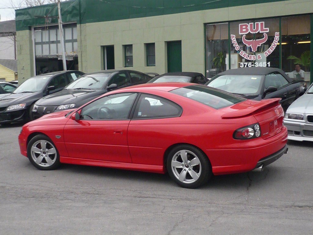 Red coupe with rear spoiler and five-spoke alloy wheels