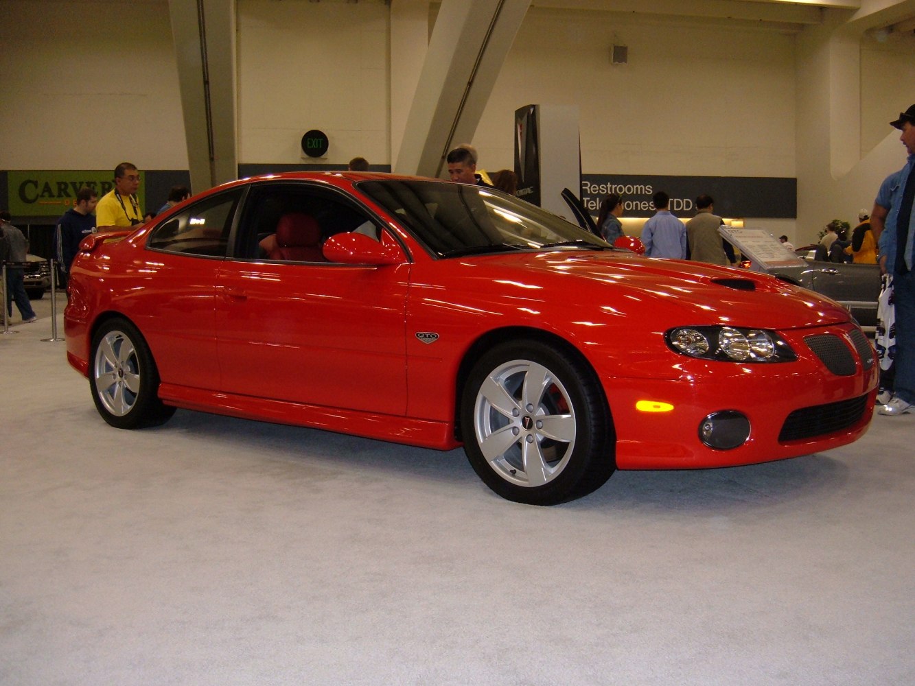 Red coupe with sporty hood vents and alloy wheels