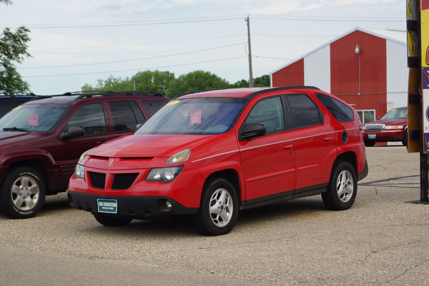 Angular front end and compact SUV silhouette in red.