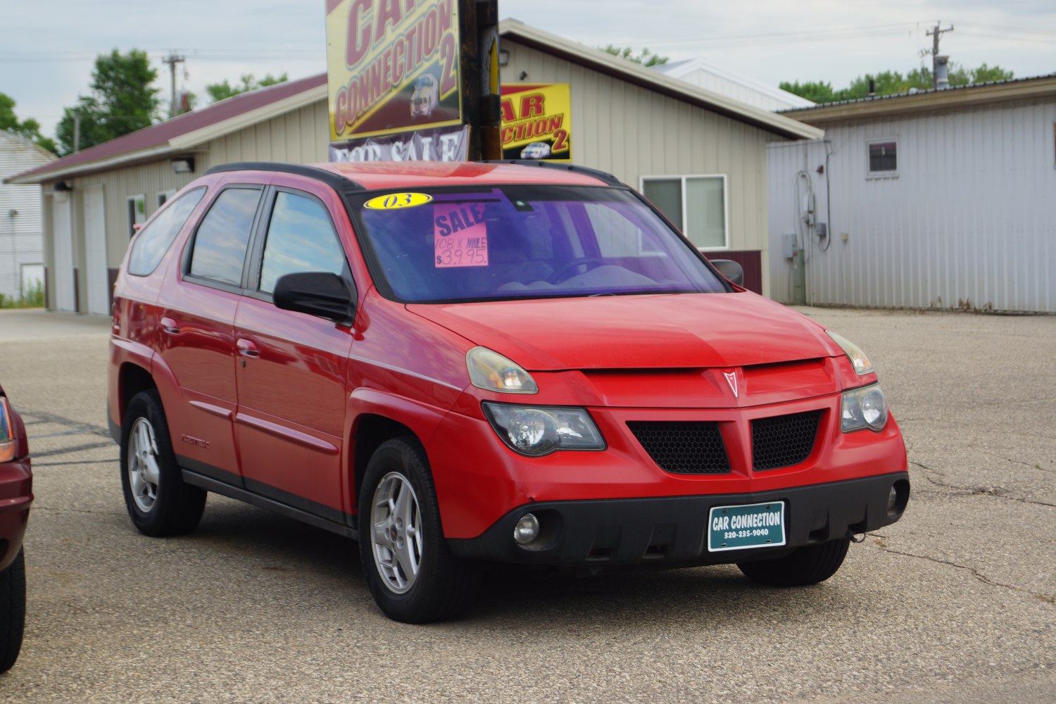 Split grille and unique dual-headlight design on red compact SUV front.