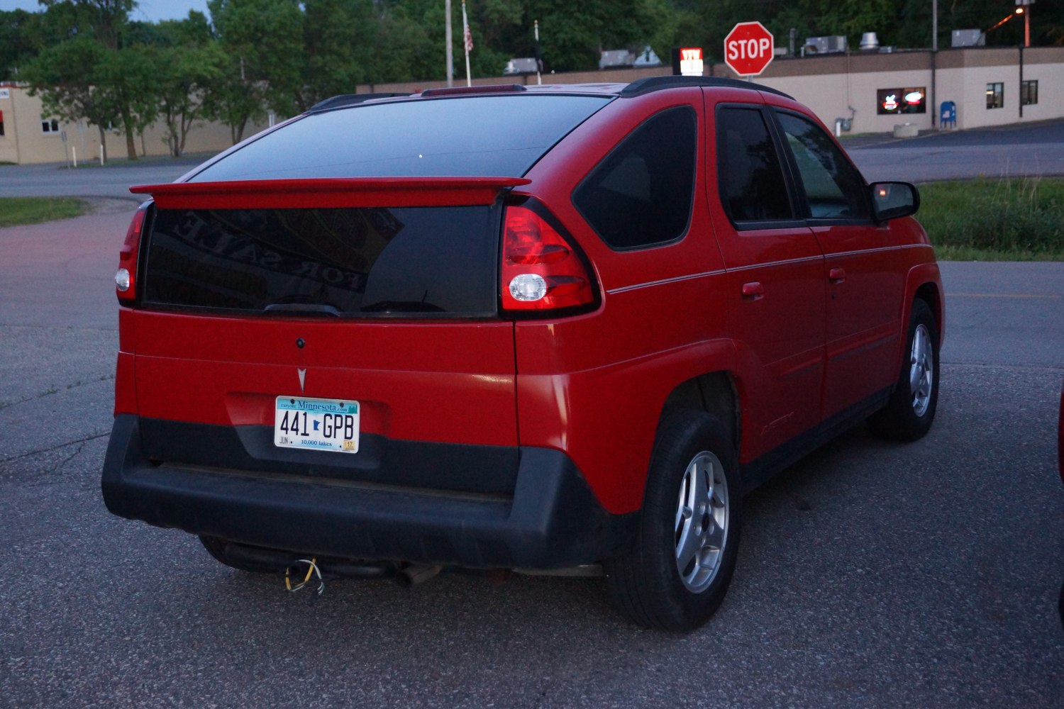 Rear view of red SUV with roof spoiler and tinted windows