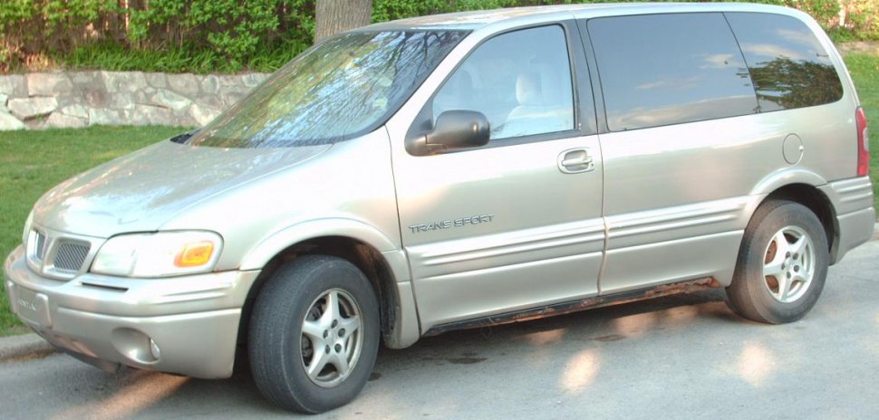 Side profile view of 1990s minivan with silver paint and tinted windows