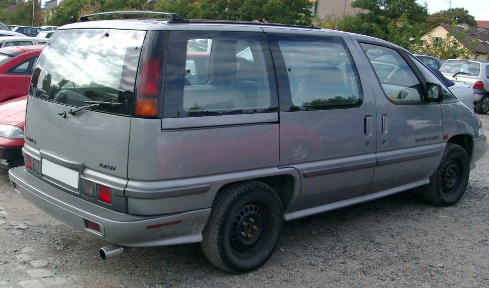 Rear side view of a minivan with sliding doors and vertical taillights.