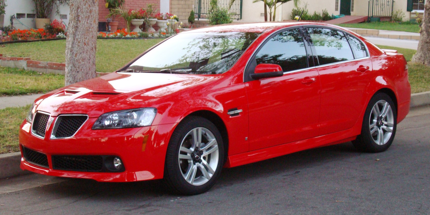 Sporty sedan front side profile with hood scoops and alloy wheels