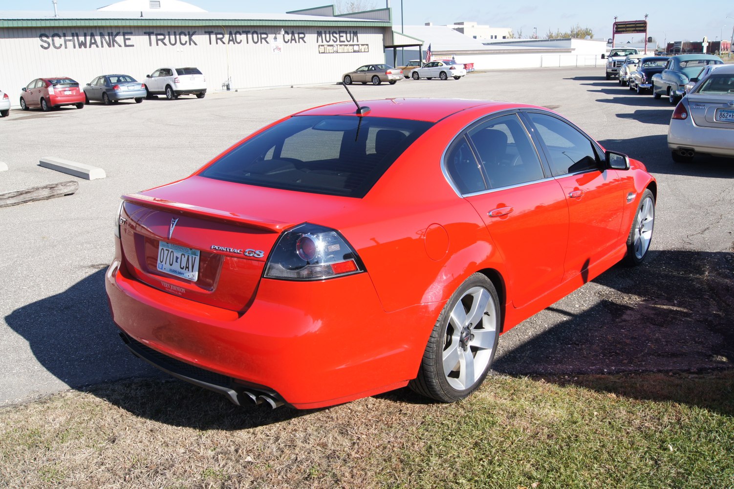 Rear view of red sedan with spoiler and dual exhaust