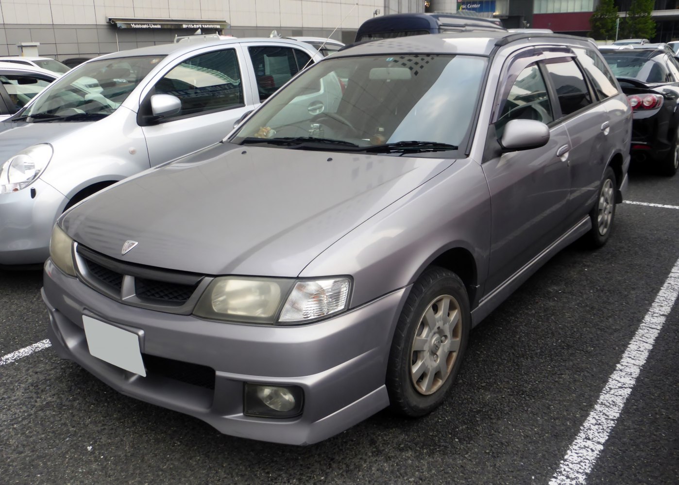 Front-side view of a classic wagon with alloy wheels and roof rails.