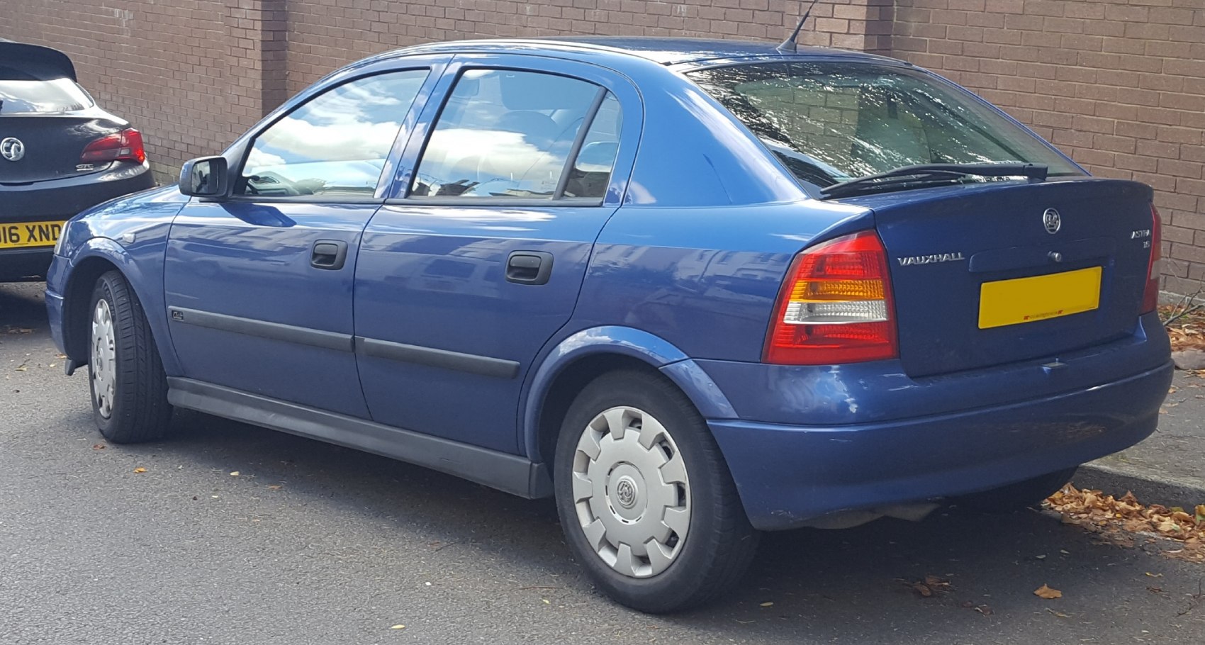 Rear side view of four-door compact sedan with distinct taillight and hubcaps