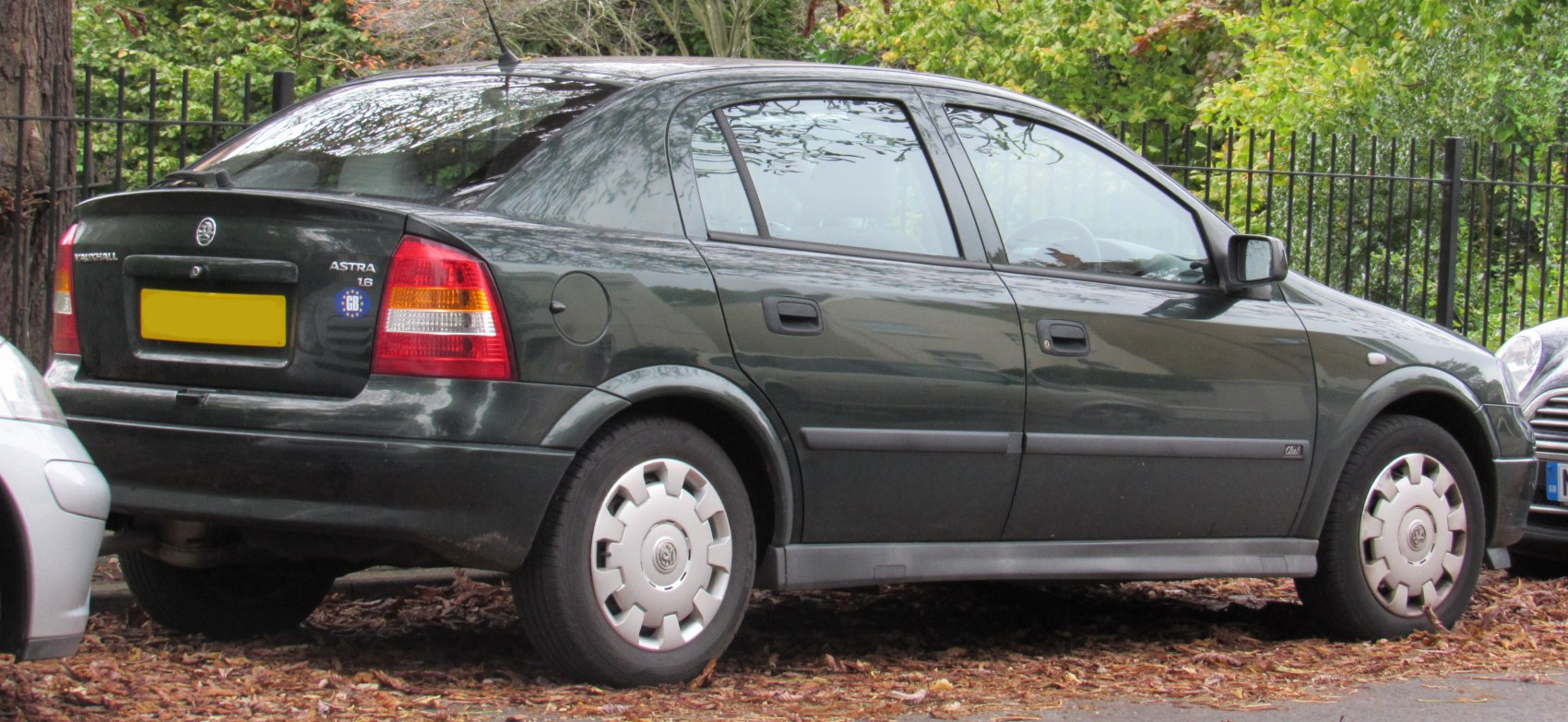 Rear three-quarter side and back view of a compact hatchback with visible rear lights and wheel covers