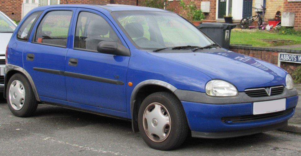 Front side view of a blue hatchback featuring rounded headlamps and compact design