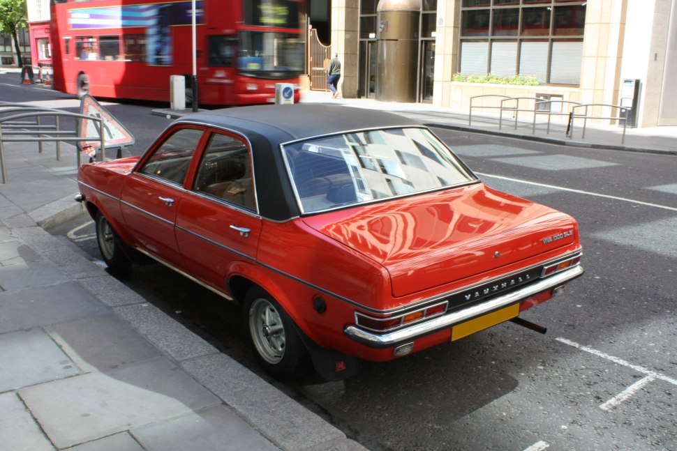 Vintage red sedan with vinyl roof and classic rear design.