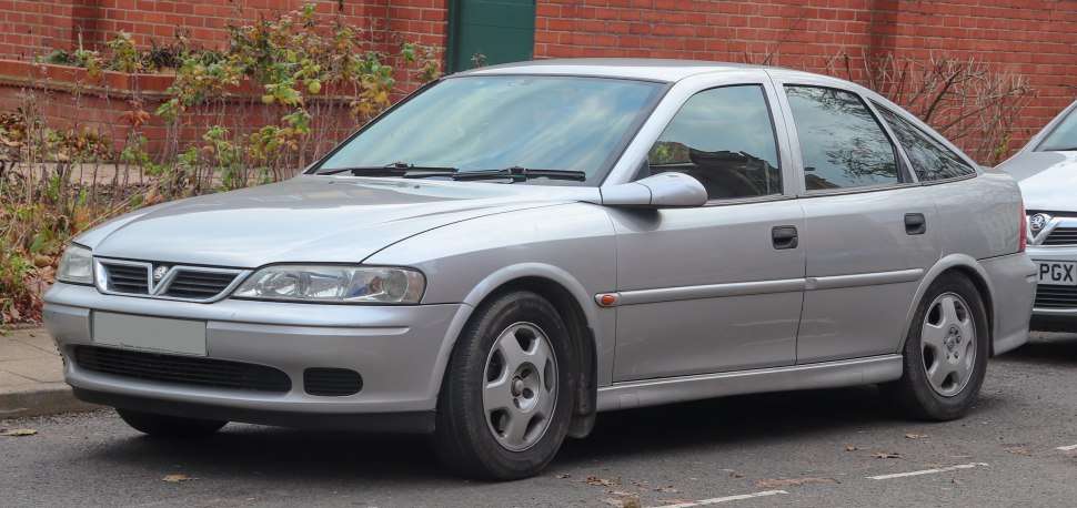 Silver four-door sedan with alloy wheels parked on street, front side view