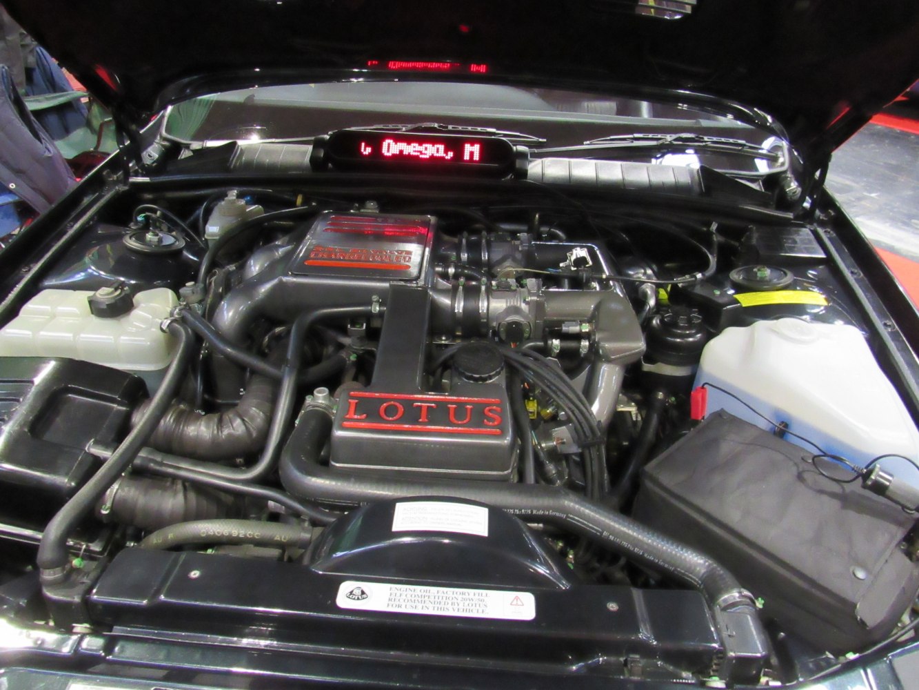 Close-up of Lotus-branded engine bay with detailed mechanical parts and hoses