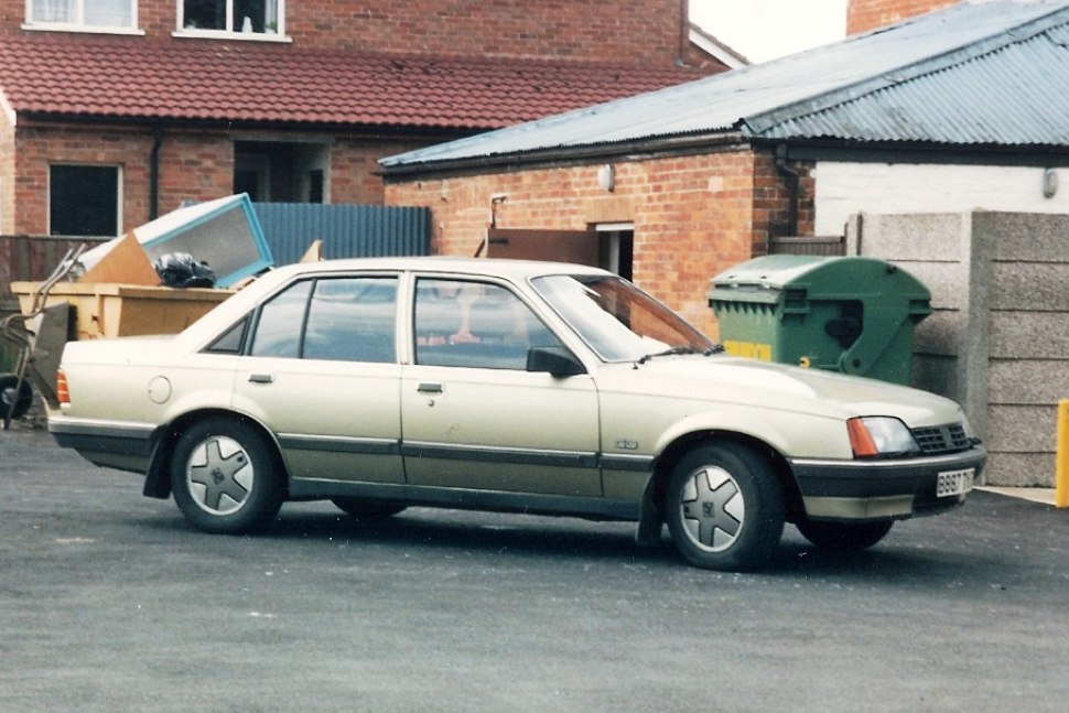 Side profile of a classic four-door sedan with distinctive wheel covers.
