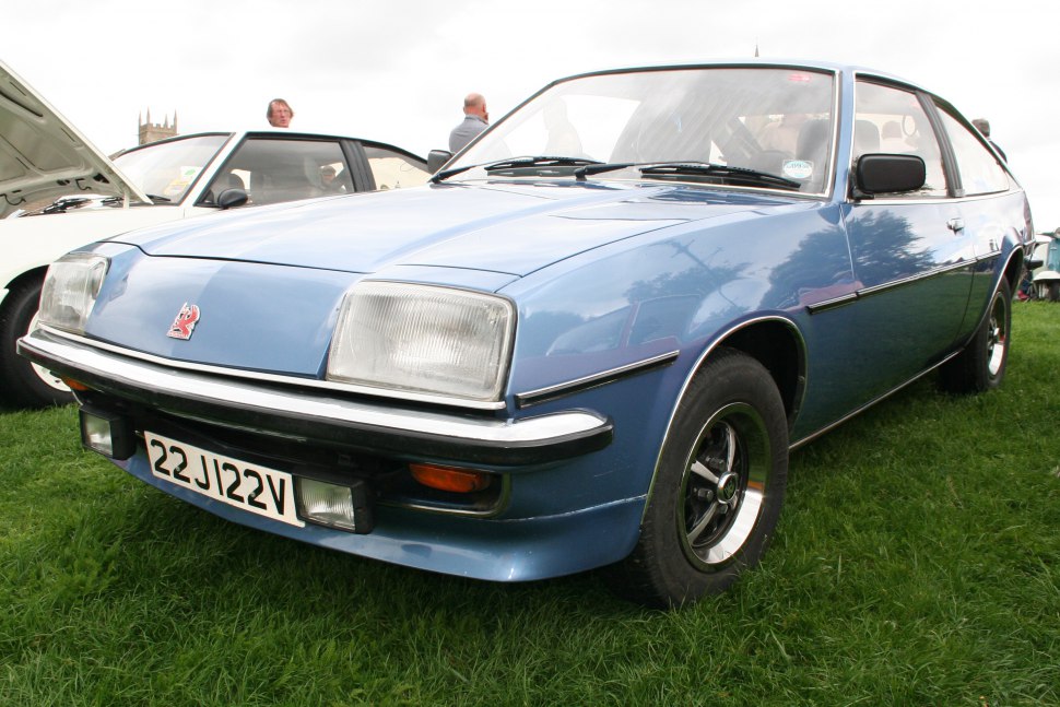Front view of vintage coupe with rectangular headlights and black-tinted wheels