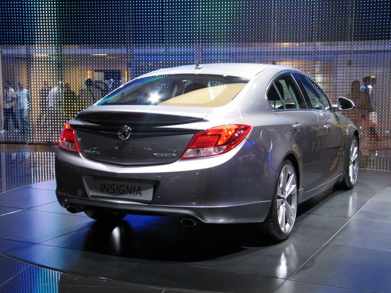 Rear view with taillights, dual exhausts, alloy wheels, and rear spoiler.