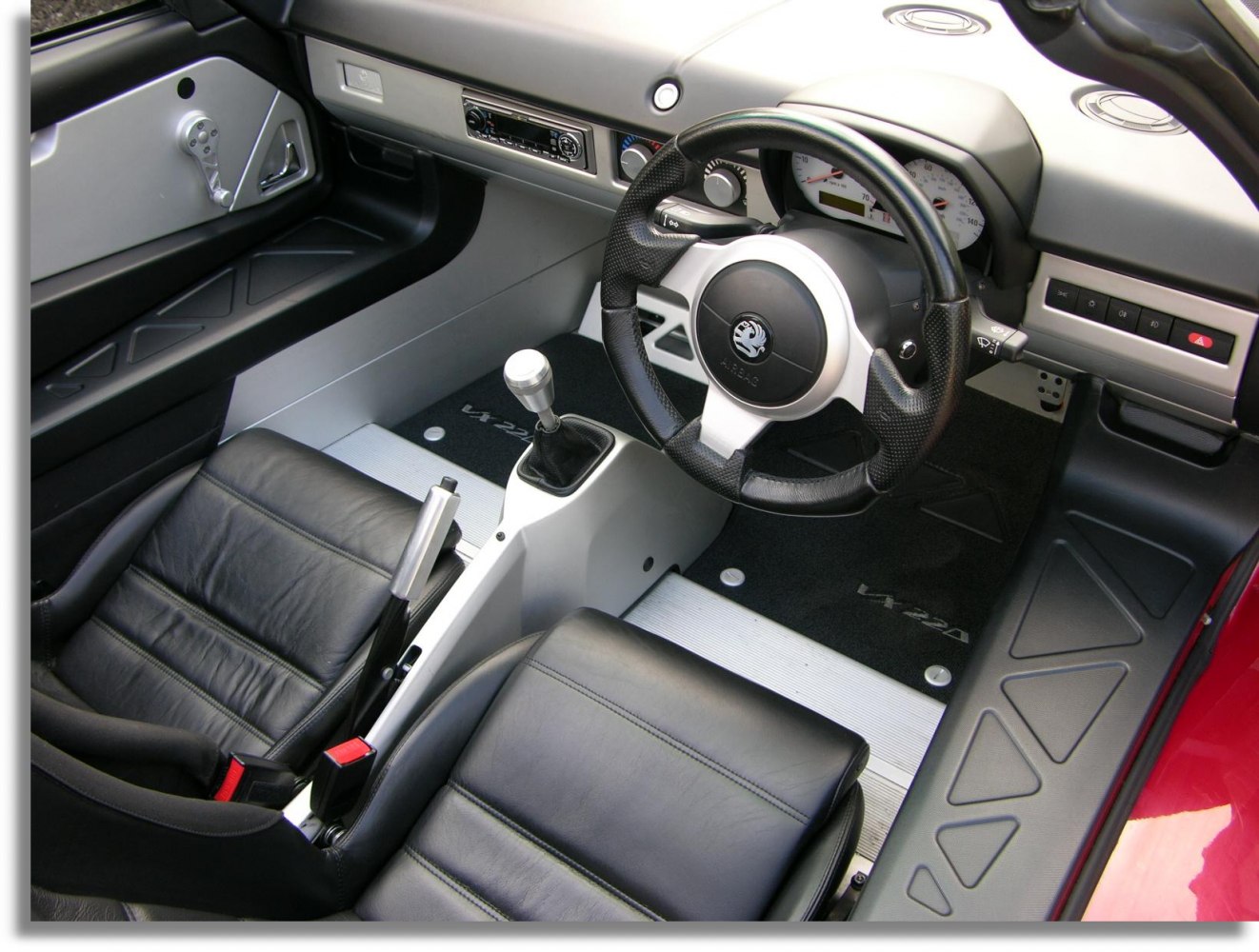 Manual gearshift and sporty steering wheel in compact car interior