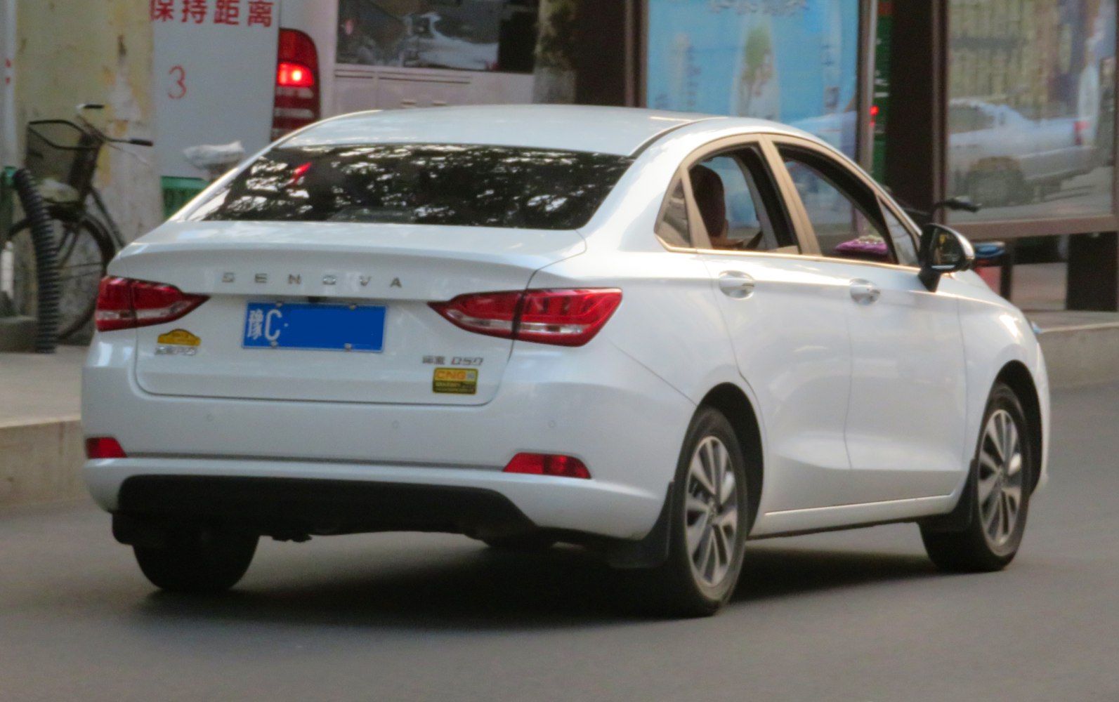 Rear and side view of a white compact sedan with distinct taillights