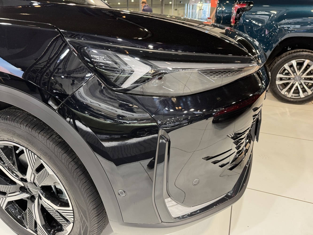 Close-up of front headlight and alloy wheel on modern vehicle