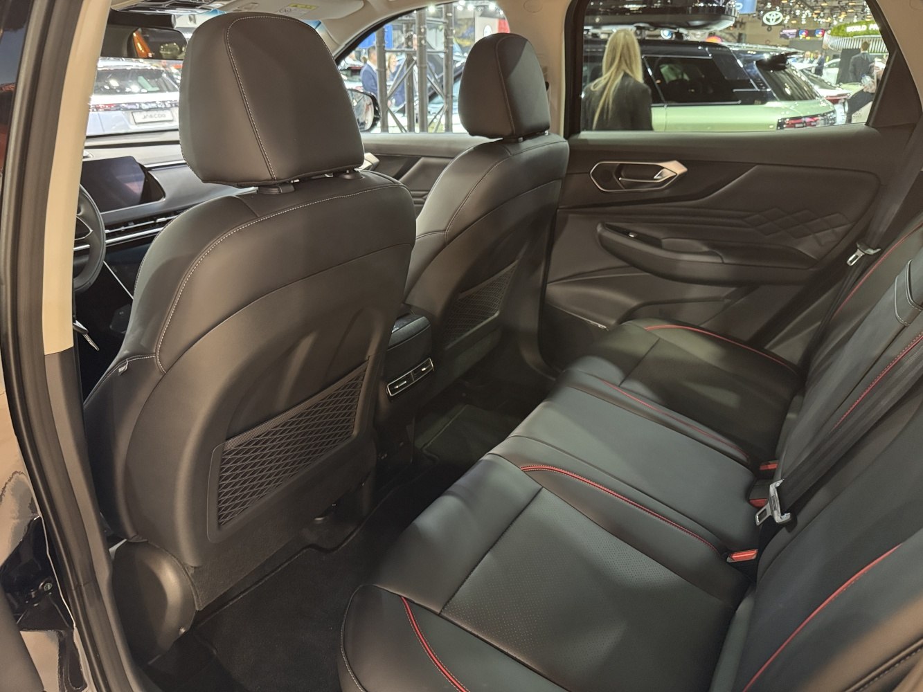 Rear leather seats with red stitching and spacious cabin interior