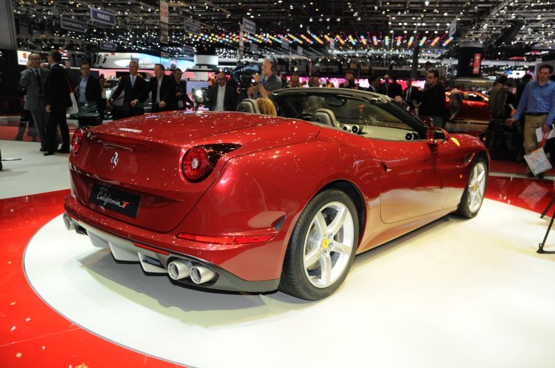 Rear view of a red convertible with quad exhaust pipes.