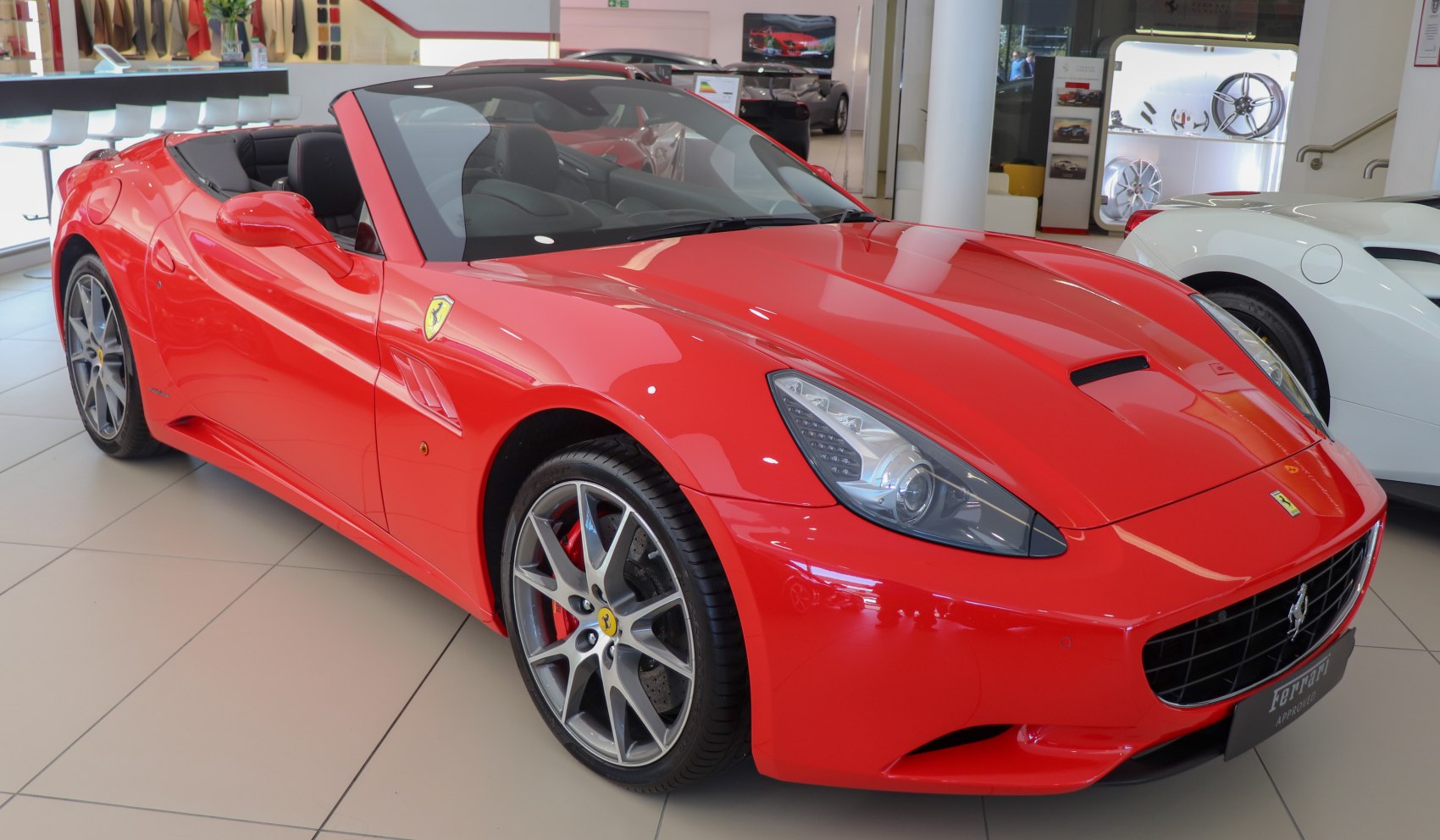 Red convertible sports car front and side view with open roof and alloy wheels