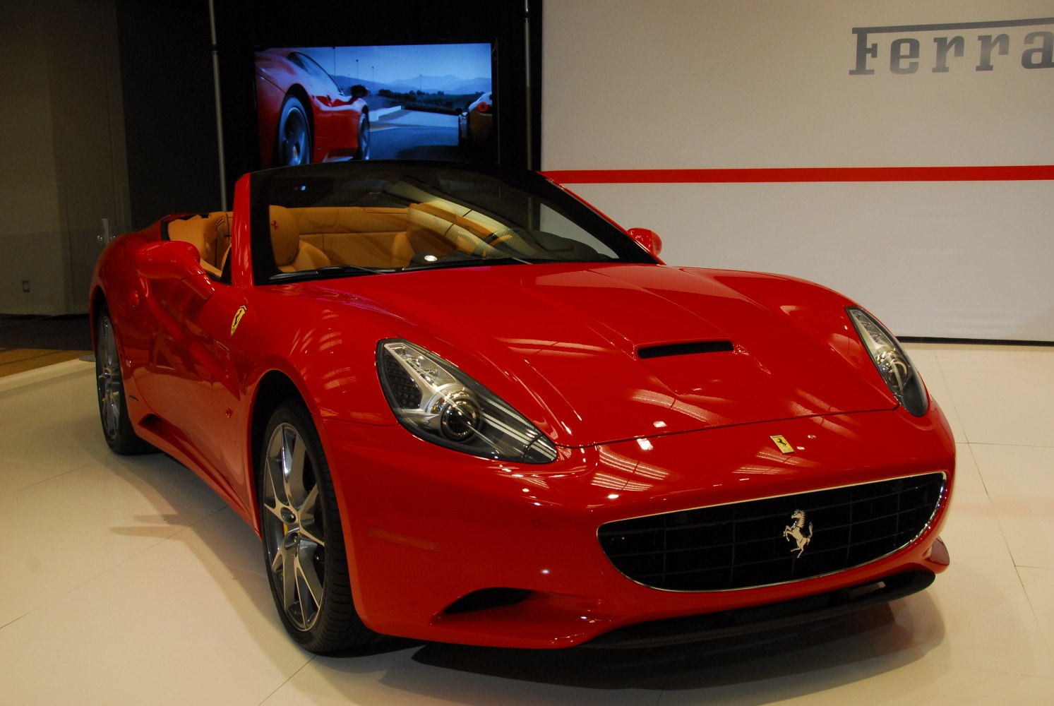 Red convertible with sleek front design and distinctive headlights