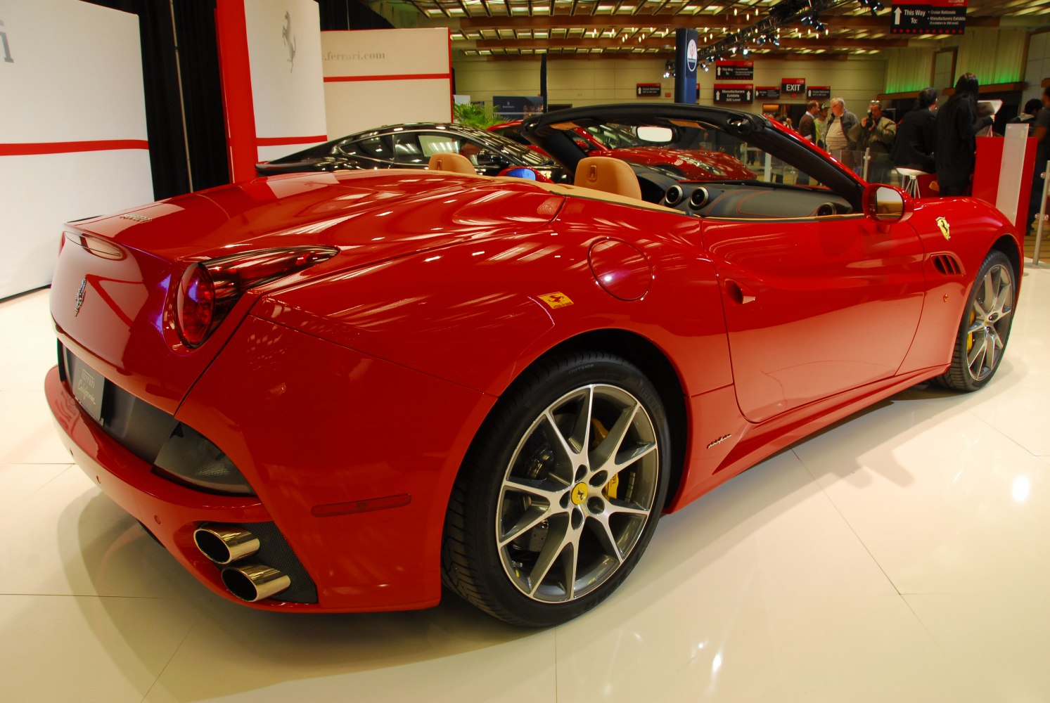 Red convertible sports car rear side with alloy wheels and dual exhaust